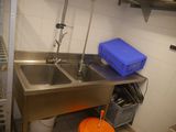 a kitchen with a sink and a bucket on the counter