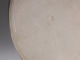 a close up of a white vase with a black rim