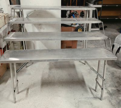 une table en métal sur laquelle se trouvent plusieurs étagères