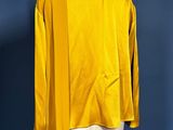 yellow jacket on a mannequin stand against a blue wall