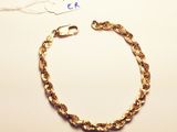 a gold chain bracelet with a clasp on a white surface