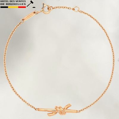 a gold bracelet with a bow on it