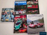 three books on a table with a racing car in front of them