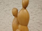 a wooden sculpture of a mother and two children