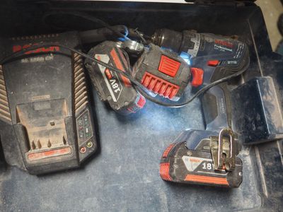 deux batteries et un chargeur dans une boîte à outils