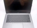 a silver laptop computer sitting on a white surface