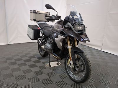 une moto qui est garée dans une pièce dont le sol est en damier