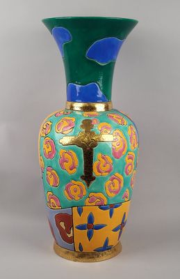 un vase orné d'une croix, posé sur une table