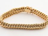 un bracelet à chaîne en or avec un fermoir sur fond blanc