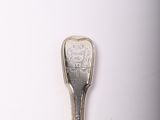 a spoon that is sitting on a white surface
