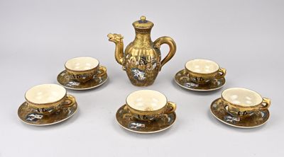cinq tasses et une théière posées sur une table