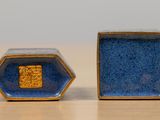 two blue and gold ceramic objects sitting on a table