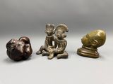 three bronze figurines of a man and a woman sitting next to each other