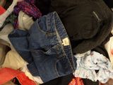 a pile of clothes sitting on top of a bed