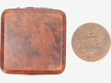 une petite boîte en métal avec une pièce à côté