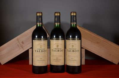 trois bouteilles de vin rouge posées sur une table, à côté d'une caisse en bois