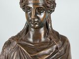 a bronze statue of a woman with a wreath on her head