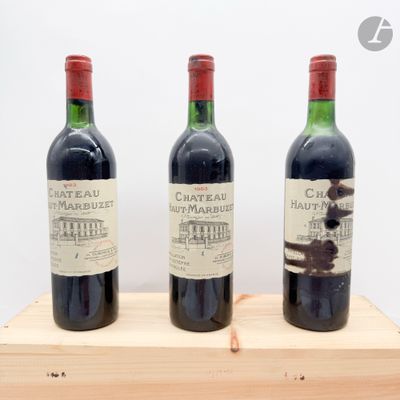trois bouteilles de vin posées sur un support en bois