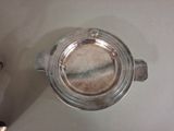 a silver cup with a lid on a table