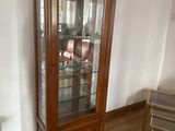 a wooden cabinet with a glass door in a room