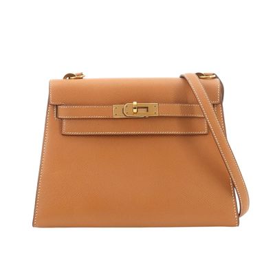 a tan leather handbag with gold hardware