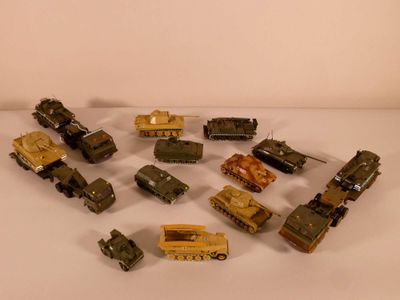 a lot of toy army vehicles on a white surface