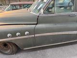 an old car that is sitting in the parking lot