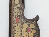a wooden object with a decorative design hanging on a wall