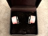 une paire de boutons de manchette roses et blancs dans un coffret noir