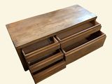 a wooden dresser with three drawers on it