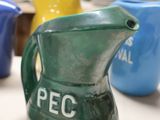 three different colored pitchers sitting on a table