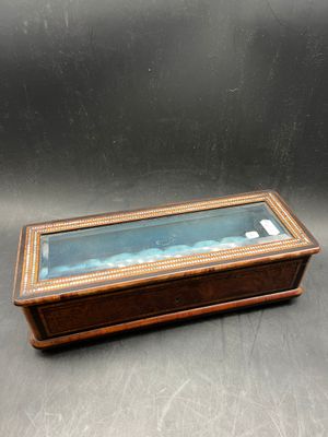 an old wooden box with a glass lid on a table