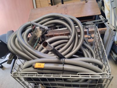 a wire basket with a bunch of hoses in it