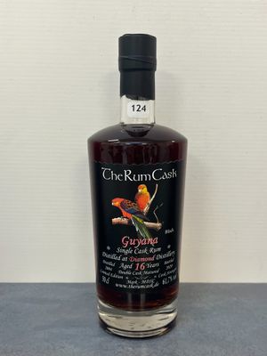 Une bouteille de rhum « Coast Rum » est posée sur une table.