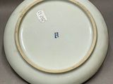 a white plate with a gold rim sitting on a table