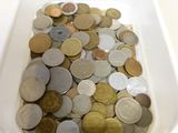 un bol blanc rempli d'une multitude de pièces de monnaie posé sur une table