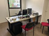 un bureau avec deux ordinateurs et une chaise devant une fenêtre