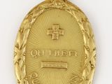 gros plan d'une médaille d'or sur une surface blanche
