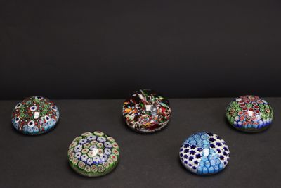 six bols en verre de couleurs différentes posés sur une surface noire