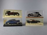 three model cars in display cases on a gray surface