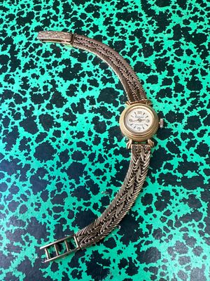 an image of a wrist watch on a green and black background