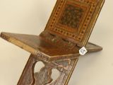 a small wooden chair that has a book on top of it