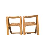 two wooden chairs sitting next to each other on top of a white surface