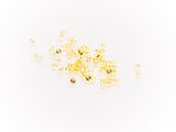 a close up of a pile of yellow beads on a white surface