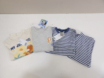 a pile of baby clothes on a white table