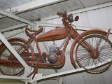 an old motorcycle hanging from the ceiling of a garage