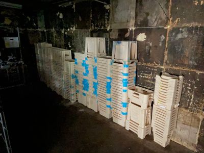 many white crates stacked up against a wall in a room