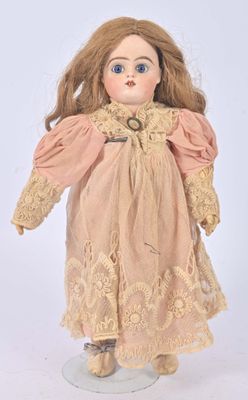 an old fashioned doll with a pink dress and brown hair