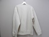 the white sweatshirt is hanging on a hanger on the wall