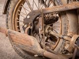 a close up of an old motorcycle with rust on the front wheel